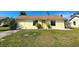 Charming single-story home with a well-maintained lawn, tidy garden bed, and inviting yellow exterior at 6113 Mckee St, Port Charlotte, FL 33981