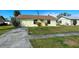 Inviting single-story home featuring a well-kept lawn, neat landscaping, and sunny yellow exterior at 6113 Mckee St, Port Charlotte, FL 33981