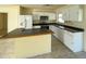 White cabinet kitchen featuring black countertops and modern appliances at 6113 Mckee St, Port Charlotte, FL 33981