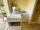 Laundry room features a washing machine, dryer, and water heater, all in pristine white at 6113 Mckee St, Port Charlotte, FL 33981