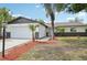 Charming single-story home features a well-maintained lawn, palm trees, and an attached two-car garage at 612 65Th W Ave, Bradenton, FL 34207