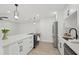 Modern kitchen featuring white cabinets, quartz countertops, stainless steel appliances, and trendy pendant lighting at 612 65Th W Ave, Bradenton, FL 34207