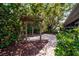 Backyard brick patio area under a pergola surrounded by lush greenery at 6512 Bowline Dr, Sarasota, FL 34231