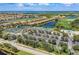 Aerial view showcasing a community with tennis courts, a pool, and lush landscaping at 6519 Grand Estuary Trl # 107, Bradenton, FL 34212