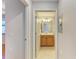 Hallway view to bathroom with a wooden vanity and a large mirror at 6519 Grand Estuary Trl # 107, Bradenton, FL 34212