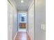 Hallway featuring two closets and an open doorway to a bathroom with tiled floors and wood vanity at 6519 Grand Estuary Trl # 107, Bradenton, FL 34212