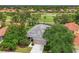 Aerial view of the home showcasing its tile roof, landscaping, and proximity to the lush golf course at 661 Foggy Morn Ln, Bradenton, FL 34212