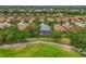 An aerial shot captures a home with a screened-in pool, surrounded by lush greenery and nearby residences at 661 Foggy Morn Ln, Bradenton, FL 34212