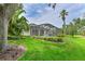 Beautifully landscaped backyard features a screened-in pool and lush tropical foliage at 661 Foggy Morn Ln, Bradenton, FL 34212
