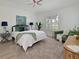 Comfortable bedroom with a queen bed, accent chair, and ample natural light at 661 Foggy Morn Ln, Bradenton, FL 34212