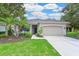 Attractive single-story home with lush landscaping, a spacious driveway, and a cozy front porch at 661 Foggy Morn Ln, Bradenton, FL 34212
