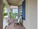 Charming front porch with brick flooring, white railing, comfortable seating, and blue shutters at 661 Foggy Morn Ln, Bradenton, FL 34212