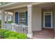 Inviting front porch with brick flooring, white railing, and comfortable seating area at 661 Foggy Morn Ln, Bradenton, FL 34212