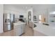 Modern kitchen with stainless steel appliances, a large island, and white cabinetry at 661 Foggy Morn Ln, Bradenton, FL 34212