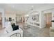 Bright and airy living space with a modern sofa, elegant decor, and open access to the kitchen at 661 Foggy Morn Ln, Bradenton, FL 34212