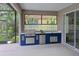 Covered outdoor kitchen featuring a grill, sink, mini-fridge, and stylish glass block window at 661 Foggy Morn Ln, Bradenton, FL 34212