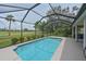 Relaxing screened-in pool with views of the well-manicured lawn and mature trees, offering a tranquil escape at 661 Foggy Morn Ln, Bradenton, FL 34212