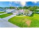 Aerial view of a white single-Gathering home on a large lot, with a big front yard and mature trees at 6627 Heritage Ln, Bradenton, FL 34209