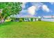 View of home's rear exterior and large green yard with fencing around the sides of the property at 6627 Heritage Ln, Bradenton, FL 34209