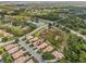 A clear aerial perspective of homes with tile roofs and solar panels nestled within green spaces and a pond at 6764 Hickory Hammock Cir, Bradenton, FL 34202