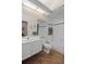 Well-lit bathroom features a tile floor, wallpaper, and white vanity with a decorative tiled shower and tub at 6764 Hickory Hammock Cir, Bradenton, FL 34202