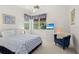 Cozy bedroom with a ceiling fan, bright natural light, a patterned bedspread, and a blue cushioned chair at 6764 Hickory Hammock Cir, Bradenton, FL 34202