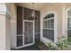 A screened front porch with tiled flooring and an ornate hanging light fixture, offering curb appeal at 6764 Hickory Hammock Cir, Bradenton, FL 34202