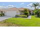 Charming single-story home with a tile roof, well-manicured lawn, and lush tropical landscaping at 6764 Hickory Hammock Cir, Bradenton, FL 34202