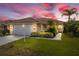 Charming single-story home with a tile roof, well-manicured lawn, and lush tropical landscaping at 6764 Hickory Hammock Cir, Bradenton, FL 34202