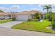 Charming single-story home with a tile roof, well-manicured lawn, and lush tropical landscaping at 6764 Hickory Hammock Cir, Bradenton, FL 34202