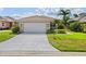 Charming single-story home with a tile roof, well-manicured lawn, and lush tropical landscaping at 6764 Hickory Hammock Cir, Bradenton, FL 34202
