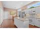 Bright, spacious kitchen featuring tiled flooring, white cabinets, an island, and modern appliances at 6764 Hickory Hammock Cir, Bradenton, FL 34202