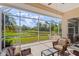 Spacious screened lanai featuring outdoor furniture and a view of the lush green lawn on a clear, sunny day at 6764 Hickory Hammock Cir, Bradenton, FL 34202