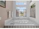 Bright bathroom with a large soaking tub under a window and neutral tile flooring at 6764 Hickory Hammock Cir, Bradenton, FL 34202