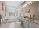 Large main bathroom features dual sinks, ample lighting, and a soaking tub by a bright window at 6764 Hickory Hammock Cir, Bradenton, FL 34202