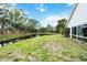Scenic backyard featuring a serene pond, lush greenery, and a brick wall at 7 Arbor Oaks Dr, Sarasota, FL 34232