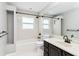 Bright bathroom with white tiled shower over tub and vanity with black fixtures at 7 Arbor Oaks Dr, Sarasota, FL 34232