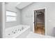 Relaxing bathroom featuring a jetted tub and adjacent bedroom access at 7 Arbor Oaks Dr, Sarasota, FL 34232