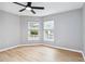 Bedroom with a ceiling fan, wood-look flooring, and two bright windows at 7 Arbor Oaks Dr, Sarasota, FL 34232