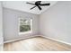 Bright bedroom featuring light-colored floors, a ceiling fan, and a large window for natural light at 7 Arbor Oaks Dr, Sarasota, FL 34232