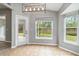 Bright breakfast nook features tile flooring, modern light fixture, and large windows with backyard view at 7 Arbor Oaks Dr, Sarasota, FL 34232