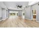 Bright living room with sliding glass doors, ceiling fan, and door to kitchen at 7 Arbor Oaks Dr, Sarasota, FL 34232