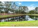 Backyard pond surrounded by a well manicured lawn and brick fence at 7 Arbor Oaks Dr, Sarasota, FL 34232