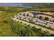 Aerial view of the condo buildings, parking, and serene lake setting surrounded by lush landscaping at 7005 River Hammock Dr # 206, Bradenton, FL 34212