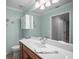 A bathroom with light blue walls, a wooden vanity, and a mirror at 7005 River Hammock Dr # 206, Bradenton, FL 34212