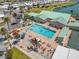 Aerial view of community pool with lounge chairs and a clubhouse in a waterfront community at 720 S Green Cir, Venice, FL 34285