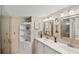 Bathroom featuring double sinks, decorative mirrors and modern white cabinets at 720 S Green Cir, Venice, FL 34285
