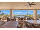 Covered outdoor patio with tables and chairs offers a relaxing waterfront view at 720 S Green Cir, Venice, FL 34285