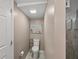 Efficient half bath with a tiled floor located off of the main bathroom at 720 S Green Cir, Venice, FL 34285