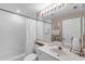 Bright bathroom featuring a white vanity, tub with shower, and decorative mirror at 7637 Sweetbay Cir, Bradenton, FL 34203